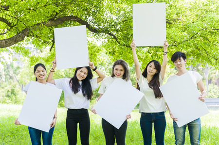 young people holding a big white boardの写真素材