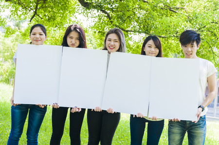 young people holding a big white boardの写真素材