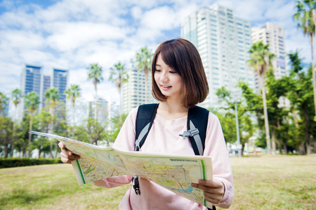 Young beautiful girl-traveler looking mapの写真素材