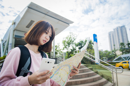 Young beautiful girl-traveler looking mapの写真素材