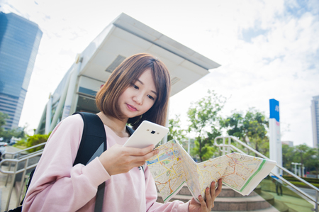 Young beautiful girl-traveler looking mapの写真素材