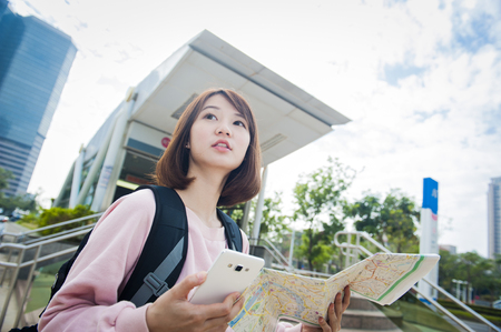 Young beautiful girl-traveler looking mapの写真素材