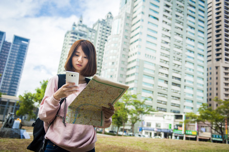 Young beautiful girl-traveler looking mapの写真素材