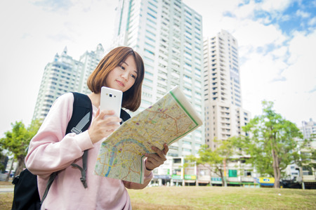 Young beautiful girl-traveler looking mapの写真素材