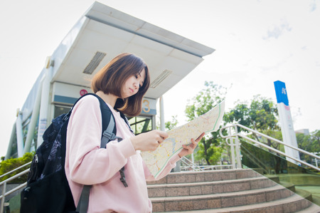 Young beautiful girl-traveler looking mapの写真素材
