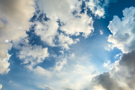 Beautiful cloudscape with large, building clouds and sunrise breaking through cloud mass.の写真素材