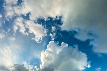Beautiful cloudscape with large, building clouds and sunrise breaking through cloud mass.の写真素材
