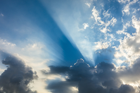 Beautiful cloudscape with large, building clouds and sunrise breaking through cloud mass.の写真素材
