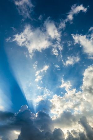 Beautiful cloudscape with large, building clouds and sunrise breaking through cloud mass.の写真素材