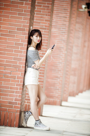 Young beautiful girl in headphones enjoying her favourite songsの写真素材