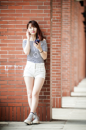 Young beautiful girl in headphones enjoying her favourite songsの写真素材