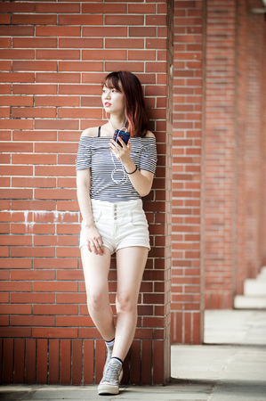 Young beautiful girl in headphones enjoying her favourite songsの写真素材