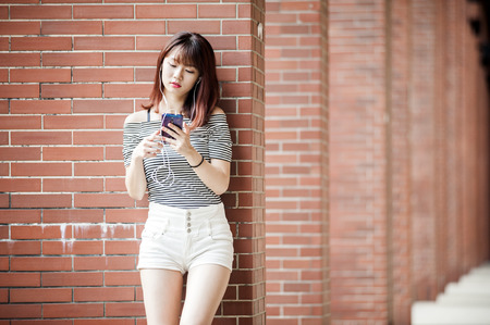 Young beautiful girl in headphones enjoying her favourite songsの写真素材
