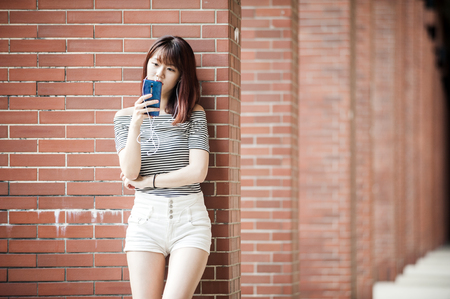 Young beautiful girl in headphones enjoying her favourite songsの写真素材