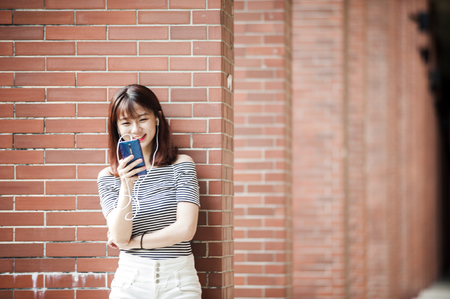 Young beautiful girl in headphones enjoying her favourite songsの写真素材