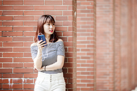 Young beautiful girl in headphones enjoying her favourite songsの写真素材