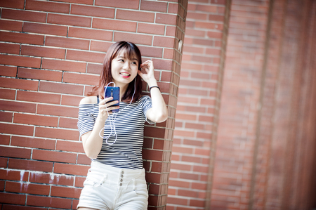 Young beautiful girl in headphones enjoying her favourite songsの写真素材