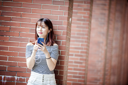 Young beautiful girl in headphones enjoying her favourite songsの写真素材