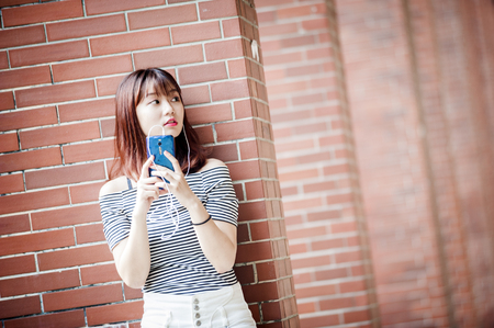 Young beautiful girl in headphones enjoying her favourite songsの写真素材