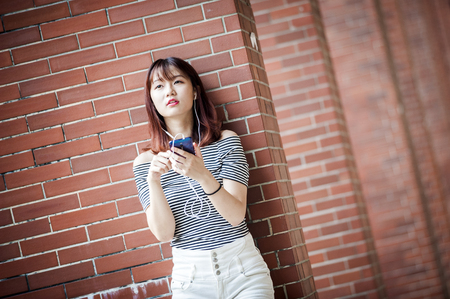 Young beautiful girl in headphones enjoying her favourite songsの写真素材