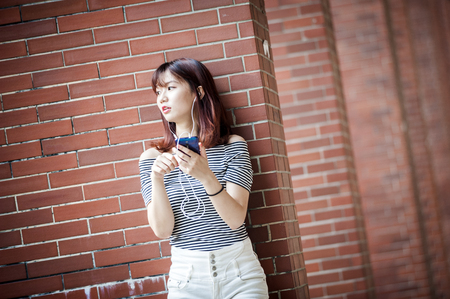 Young beautiful girl in headphones enjoying her favourite songsの写真素材