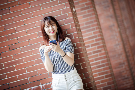 Young beautiful girl in headphones enjoying her favourite songsの写真素材