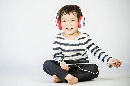 Boy listen to music on a white backgroundの写真素材
