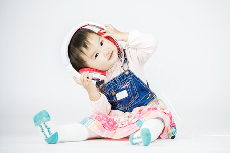 Children listen to music on a white backgroundの写真素材