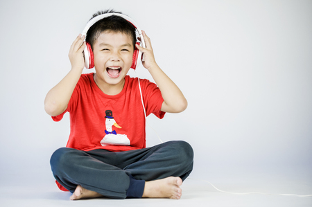 Boy listen to music on a white backgroundの写真素材