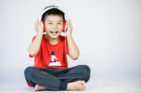 Boy listen to music on a white backgroundの写真素材