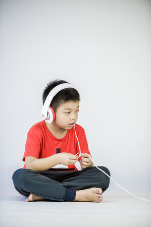 Boy listen to music on a white backgroundの写真素材
