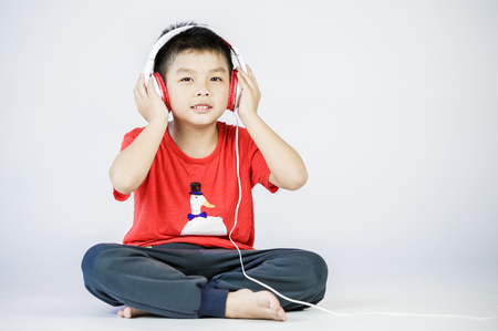 Boy listen to music on a white backgroundの写真素材