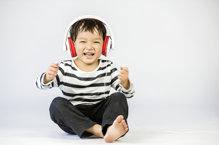 Boy listen to music on a white backgroundの写真素材