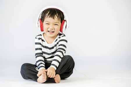 Boy listen to music on a white backgroundの写真素材