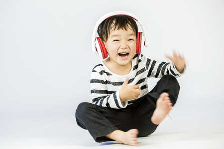 Boy listen to music on a white backgroundの写真素材