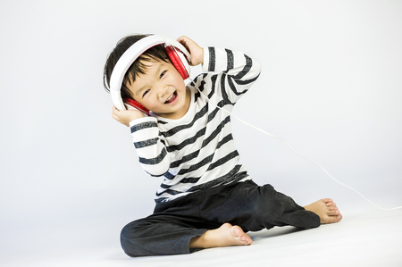 Boy listen to music on a white backgroundの写真素材
