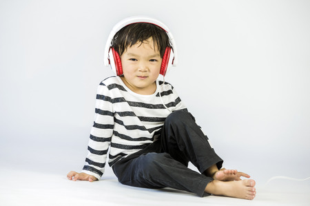 Boy listen to music on a white backgroundの写真素材