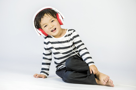 Boy listen to music on a white backgroundの写真素材