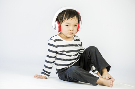 Boy listen to music on a white backgroundの写真素材