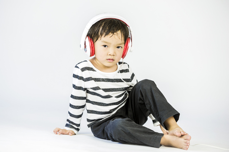 Boy listen to music on a white backgroundの写真素材