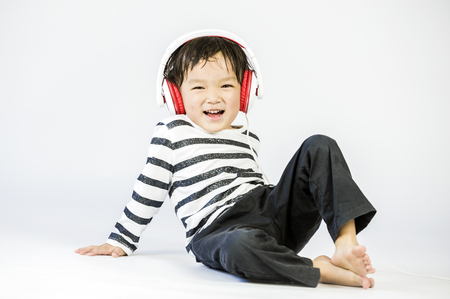 Boy listen to music on a white backgroundの写真素材