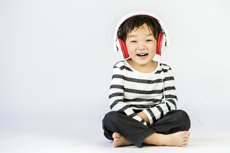 Boy listen to music on a white backgroundの写真素材