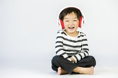 Boy listen to music on a white backgroundの写真素材