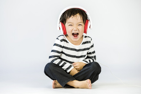 Boy listen to music on a white backgroundの写真素材