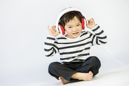Boy listen to music on a white backgroundの写真素材