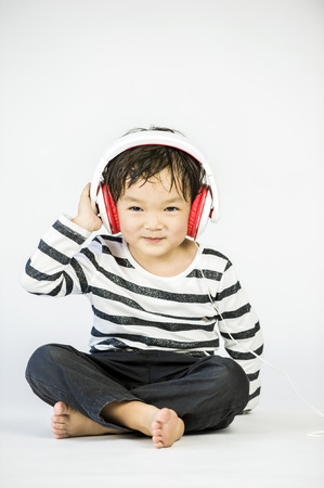 Boy listen to music on a white backgroundの写真素材