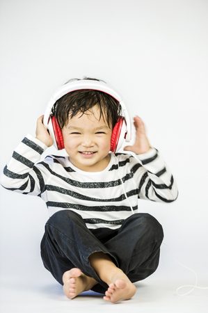 Boy listen to music on a white backgroundの写真素材