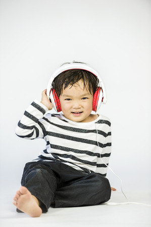 Boy listen to music on a white backgroundの写真素材