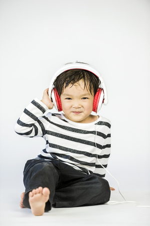 Boy listen to music on a white backgroundの写真素材