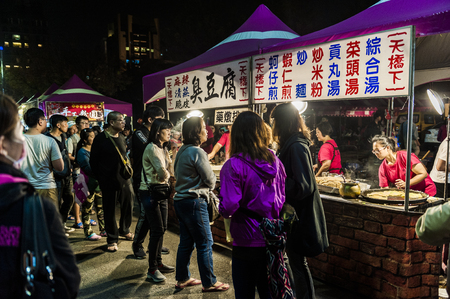 Kenting, Taiwan - February 24, 2018: Vendor prepares food at the Kenting main street night market located in Pingtung County.のeditorial素材
